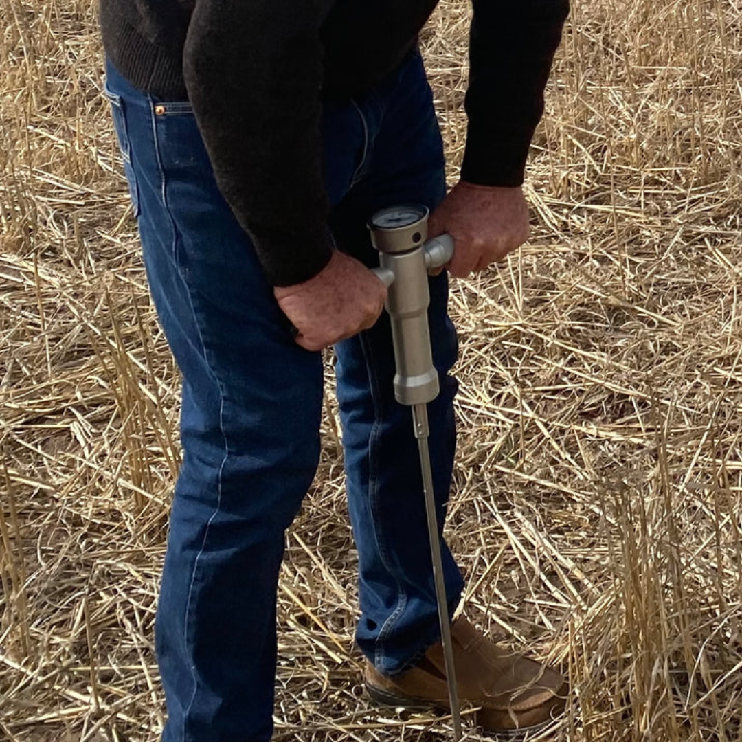Farmer using AGIMATE soil penetrometer in agricultural field to measure soil compaction and improve crop planning decisions